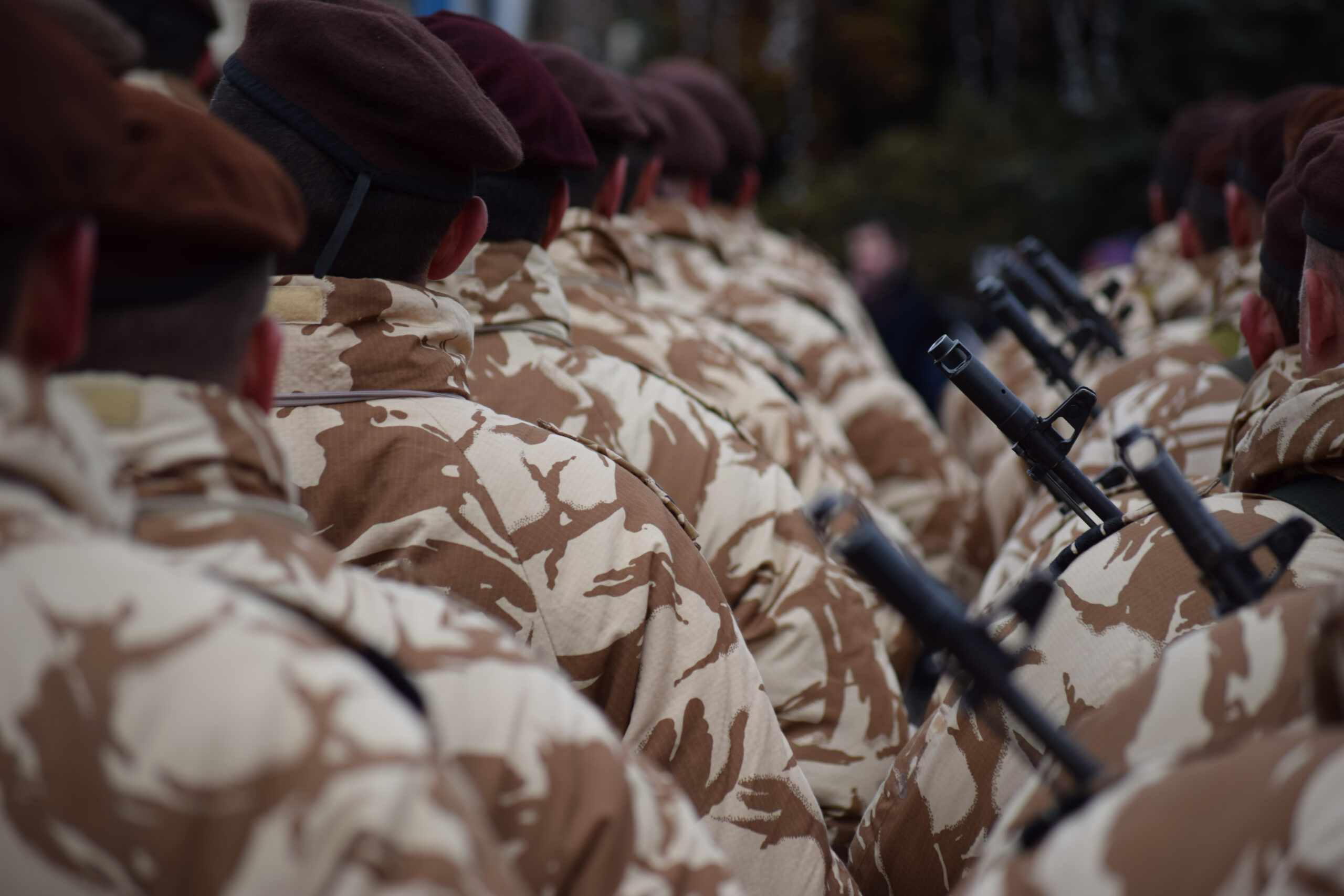 Selective shot of an army from the backside walking in a line on the blurred background