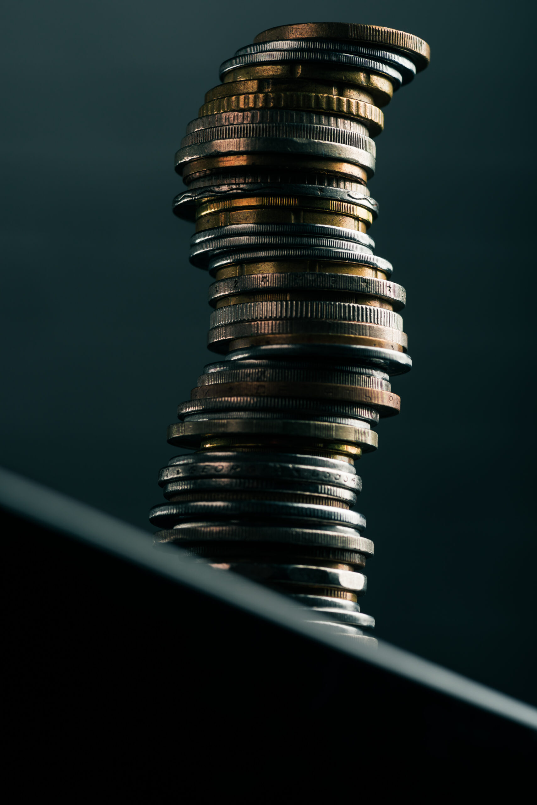 close up view of stack of different coins standing on edge of table