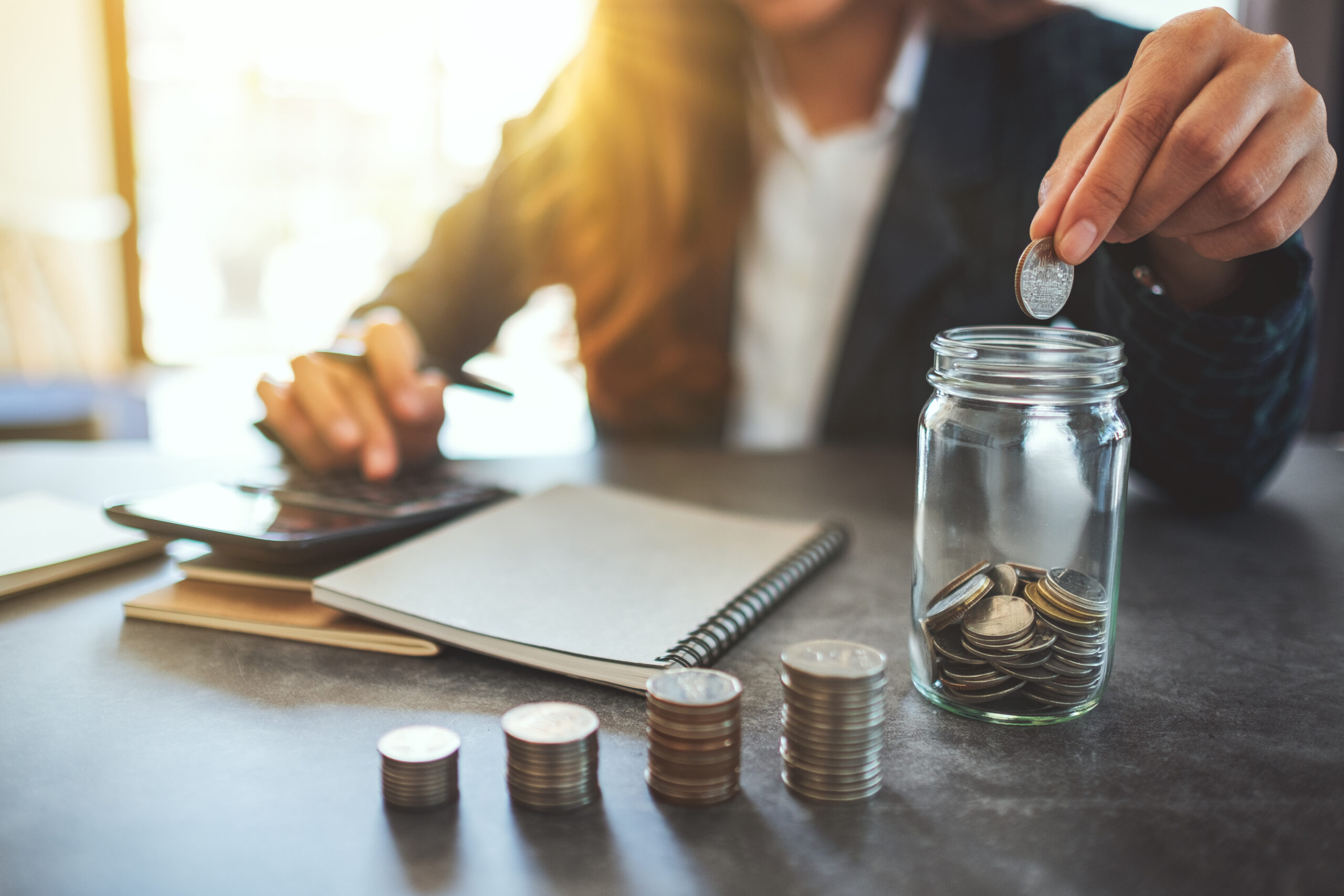 Closeup image of a businesswoman stacking and putting coins in a