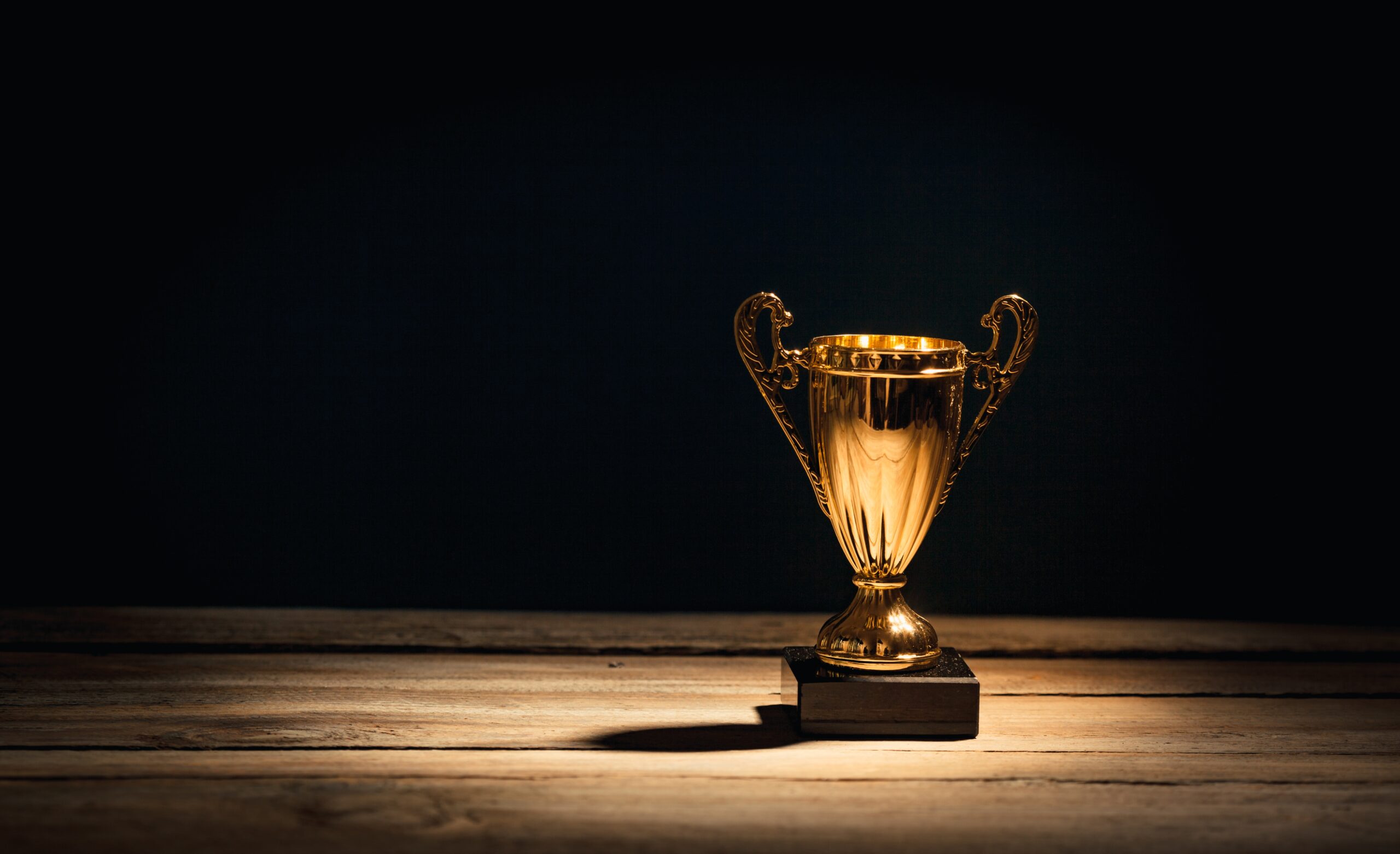 Golden trophy cup with dramatic light on table